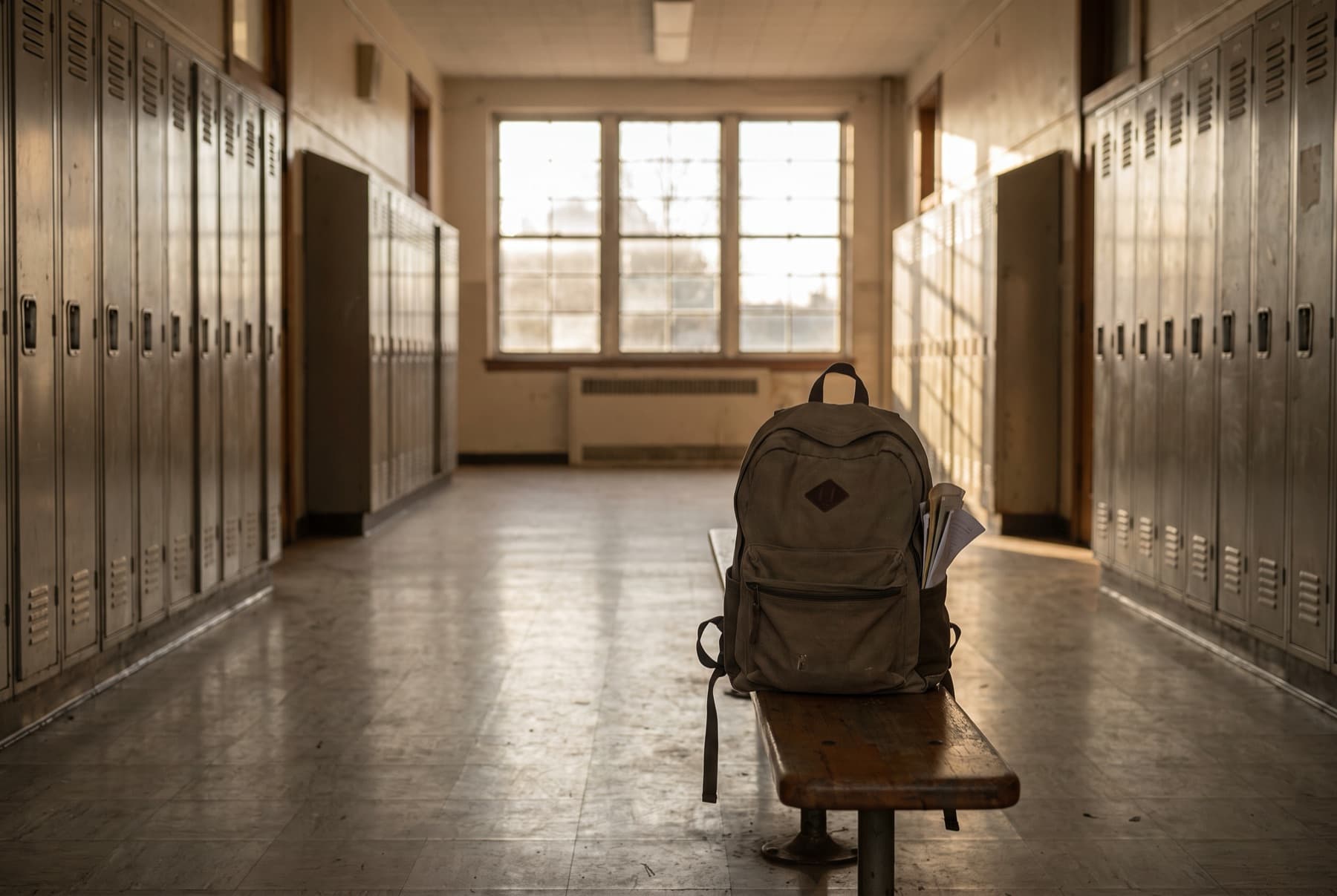 An empty school hallway with lockers in soft afternoon light
